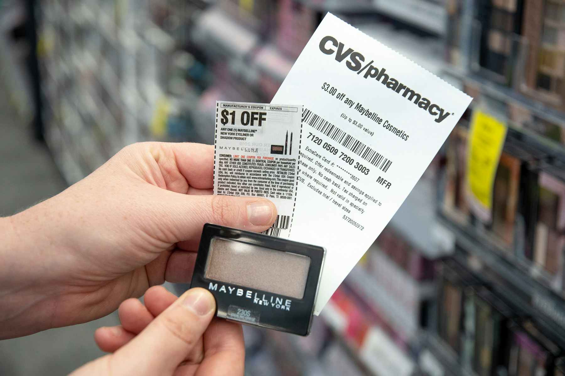 Someone holding some coupons and makeup at CVS