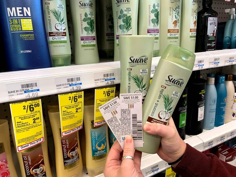someone holding suave shampoo with coupons
