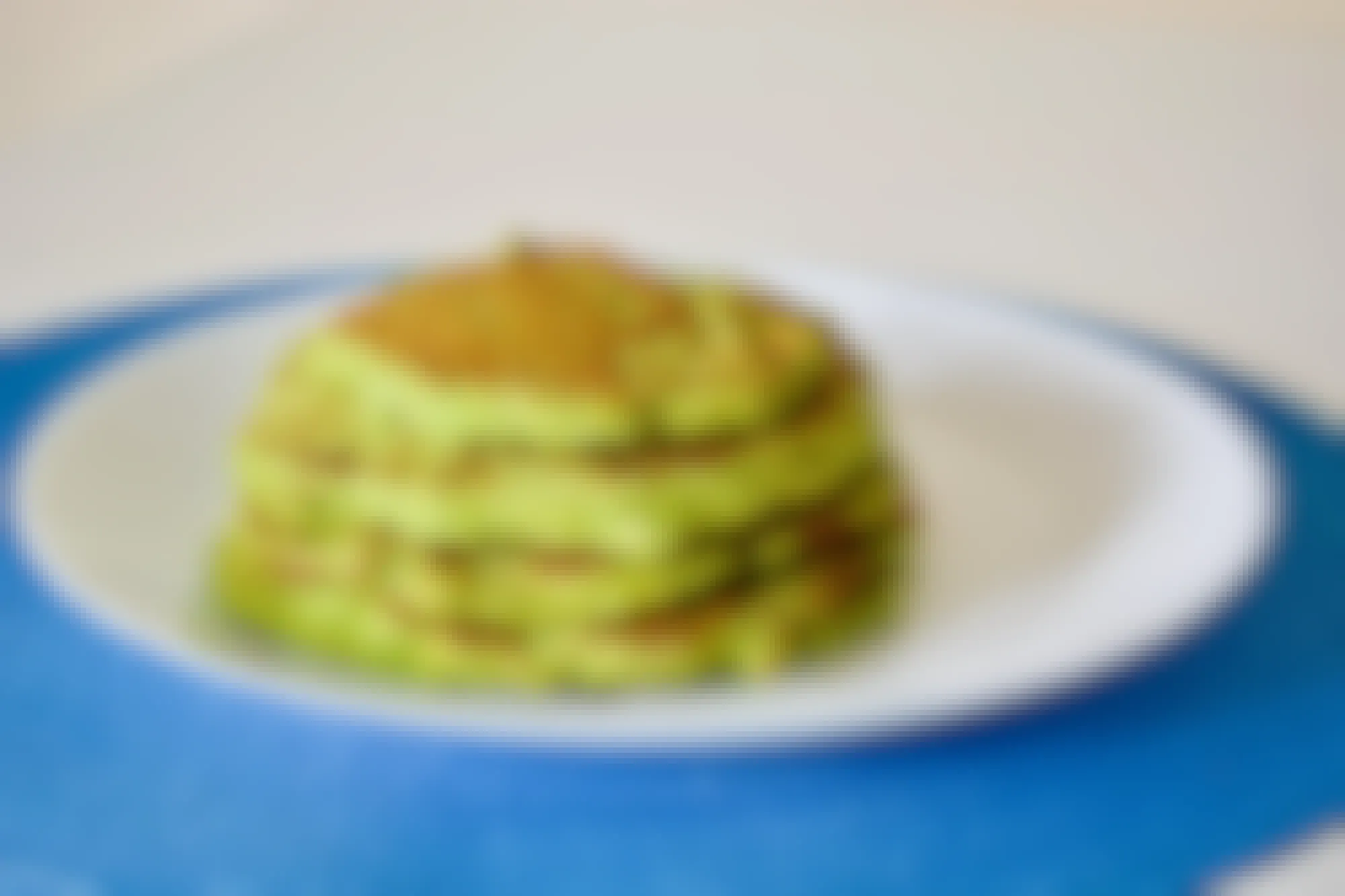 A stack of green pancakes on a plate