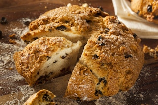 A loaf of Irish soda bread with a piece cut out