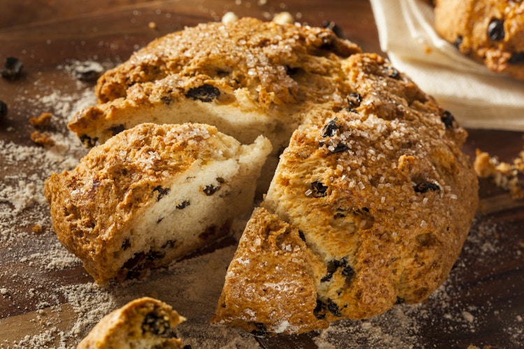 A loaf of Irish soda bread with a piece cut out