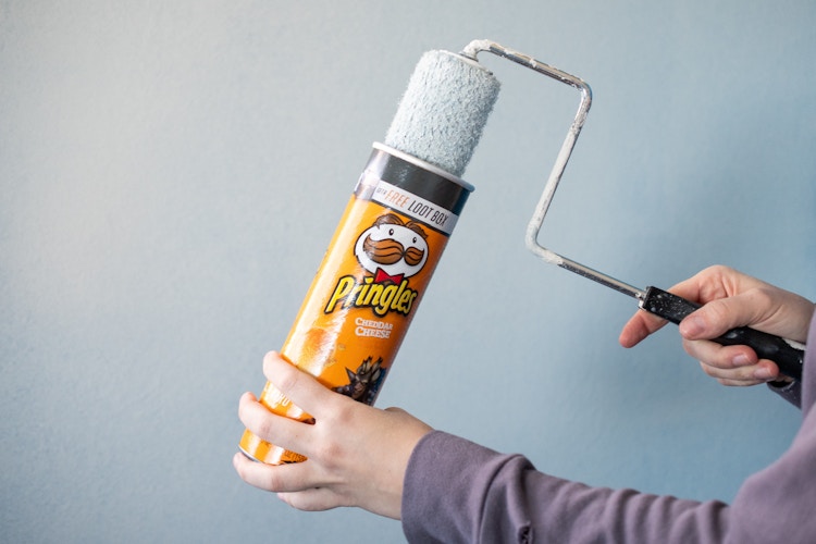 someone putting a roller brush in a pringle can