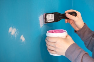 someone filling in holes in wall