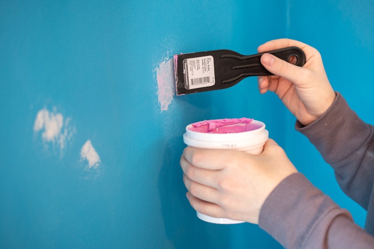 someone filling in holes in wall