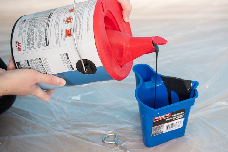 someone using a store and pour lid to pour paint