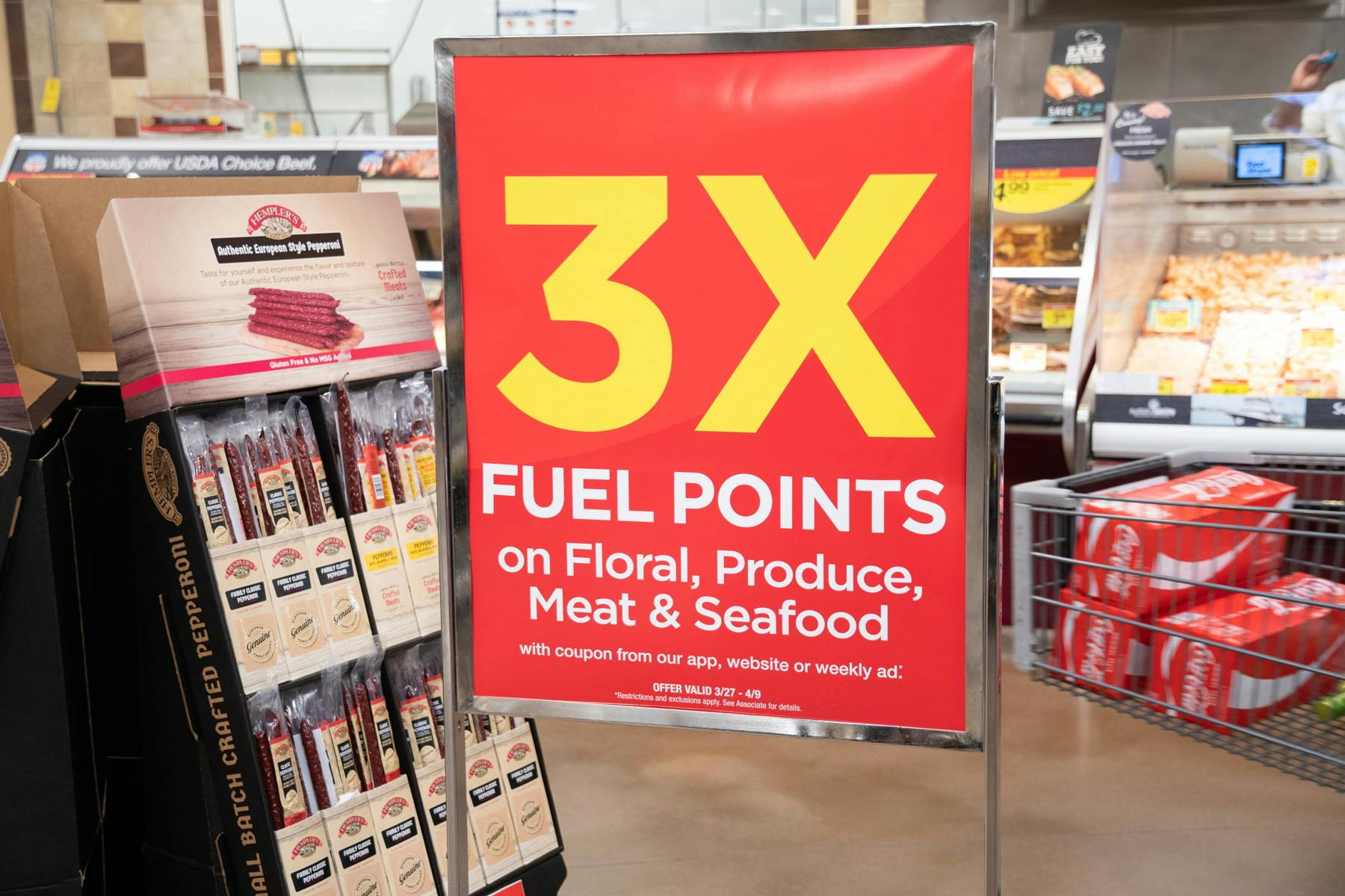A sign inside Kroger advertising 3x fuel points on Floral, Produce, or Meat & Seafood.