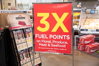 A sign inside Kroger advertising 3x fuel points on Floral, Produce, or Meat & Seafood.