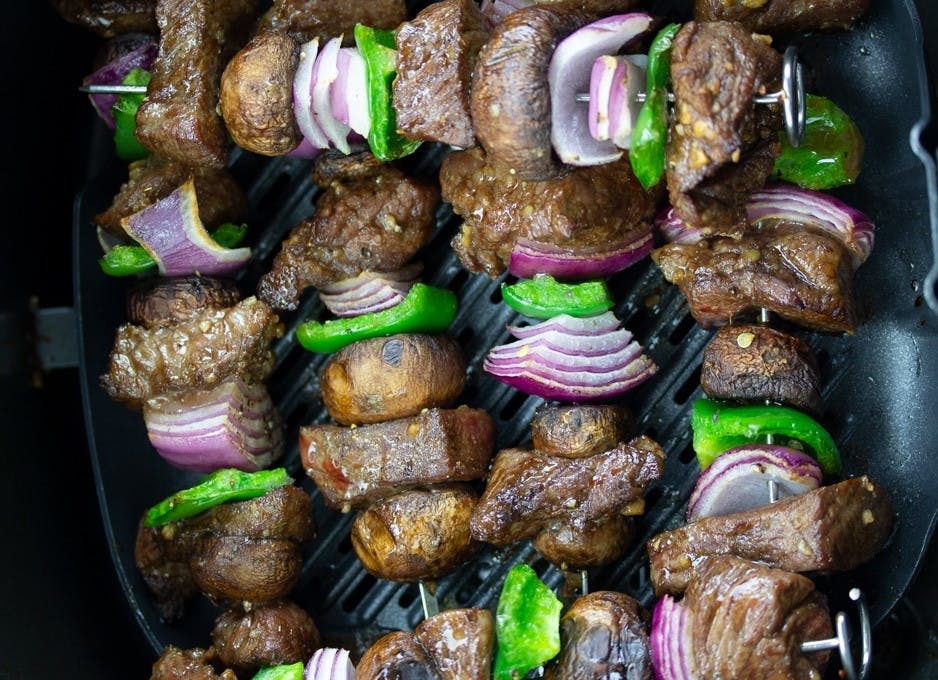 Steak, onion and pepper kababs on skewers in an air fryer