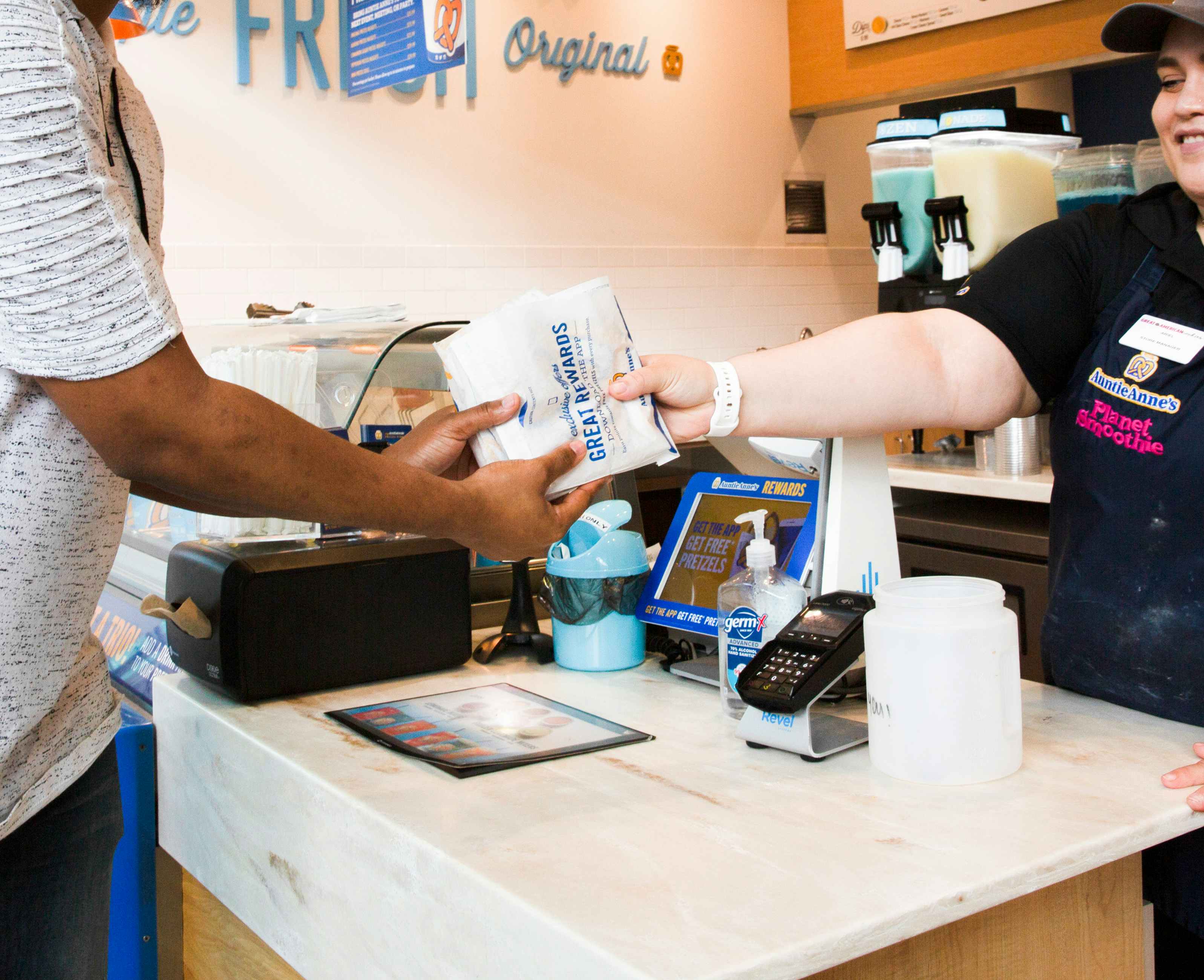 Auntie Anne's Pretzel being handed to a customer from an employee