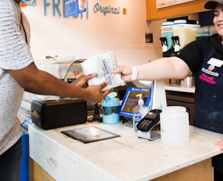 Auntie Anne's Pretzel being handed to a customer from an employee