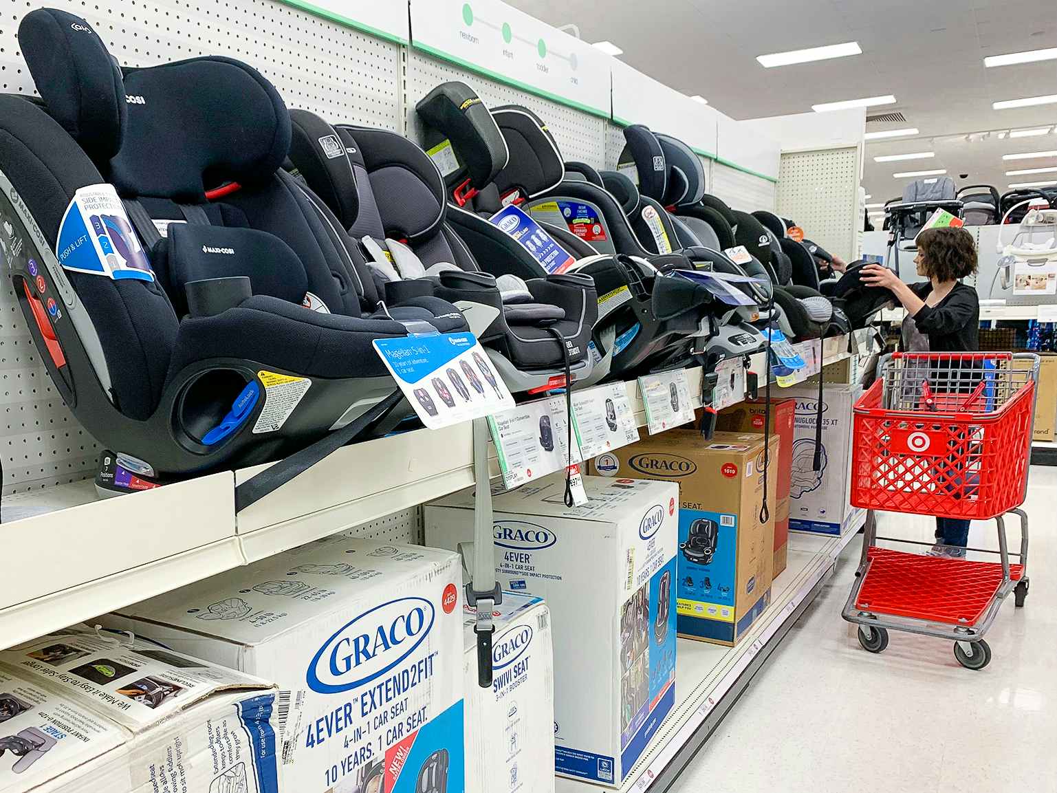 A woman shopping in the Car Seat aisle at Target.