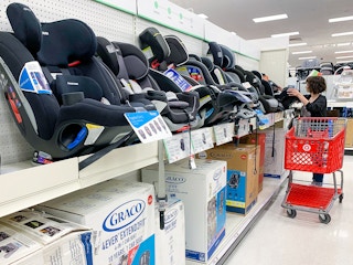 A woman shopping in the Car Seat aisle at Target.