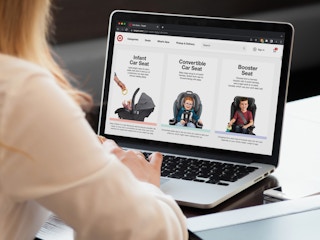 A person shopping on a laptop displaying Target.com's Car Seat page.