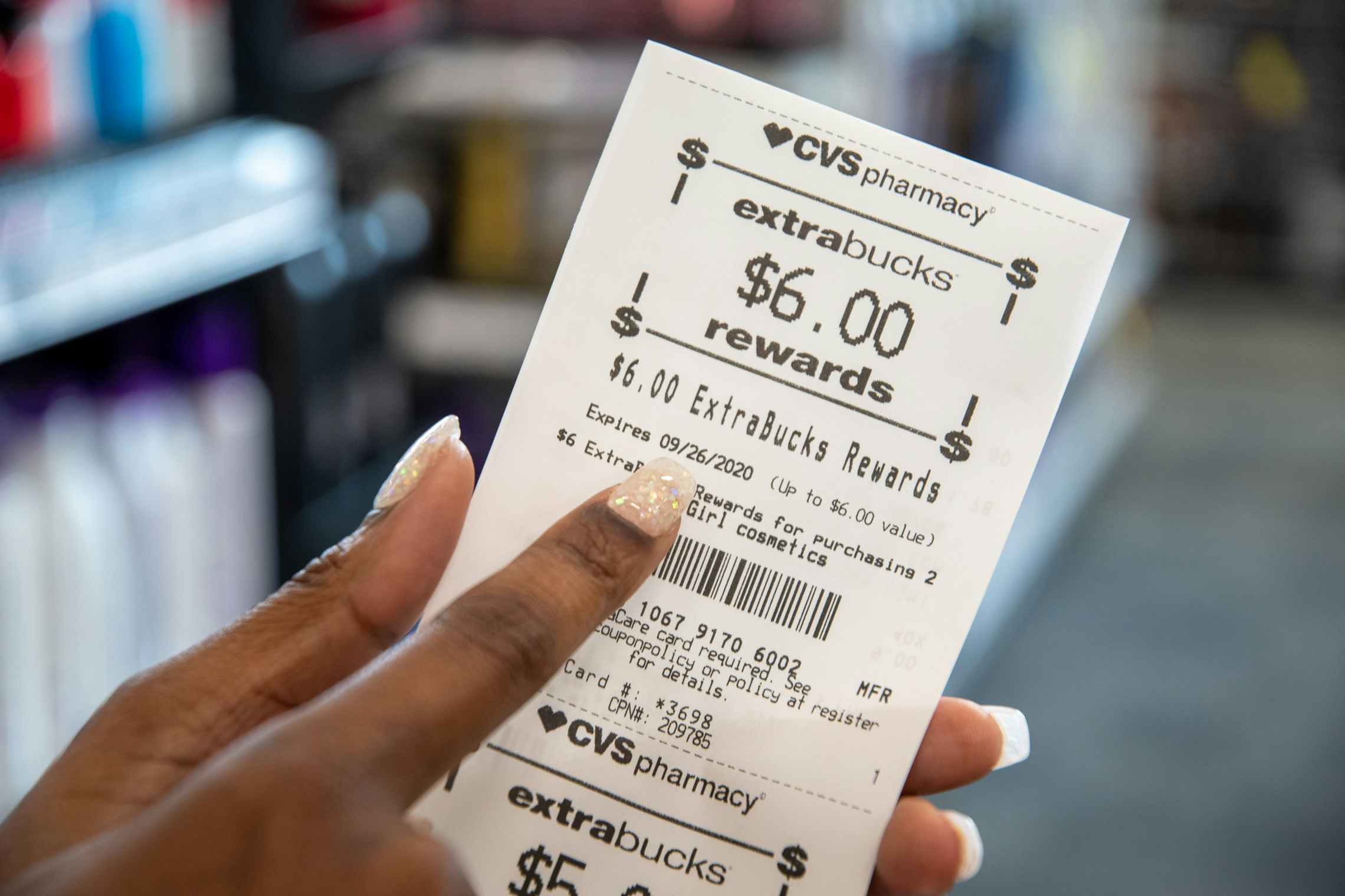 A person pointing to the expiration date on CVS Extrabucks rewards.
