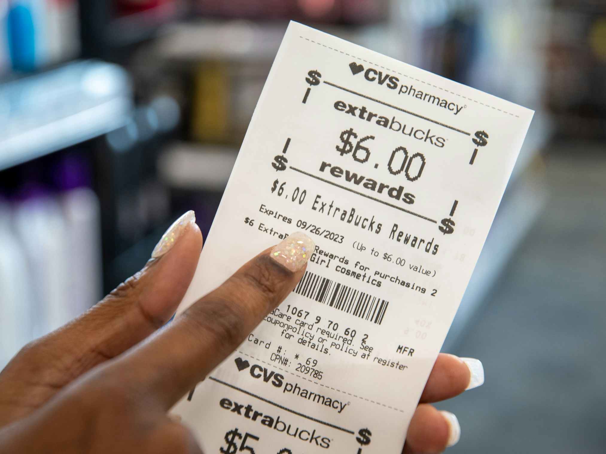 Someone pointing to the expiration date on a CVS Rewards receipt