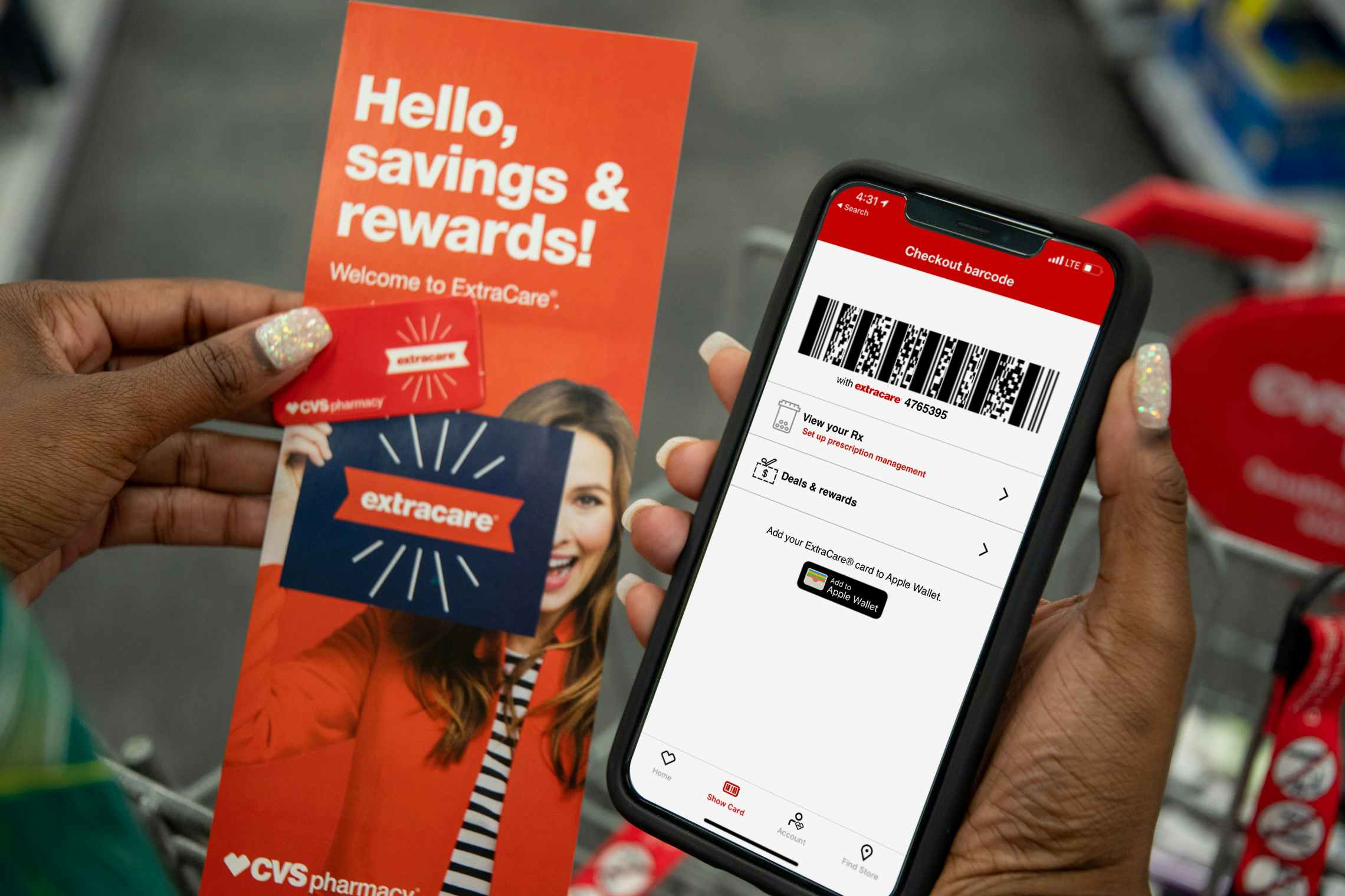 A woman holding an iPhone displaying her ExtraCare barcode on the CVS app, a rewards key chain card, and an extracare rewards pamphlet inside a CVS..