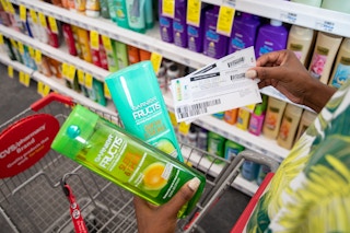 Two $1 coupons next to a bottle of shampoo and a bottle of conditioner.