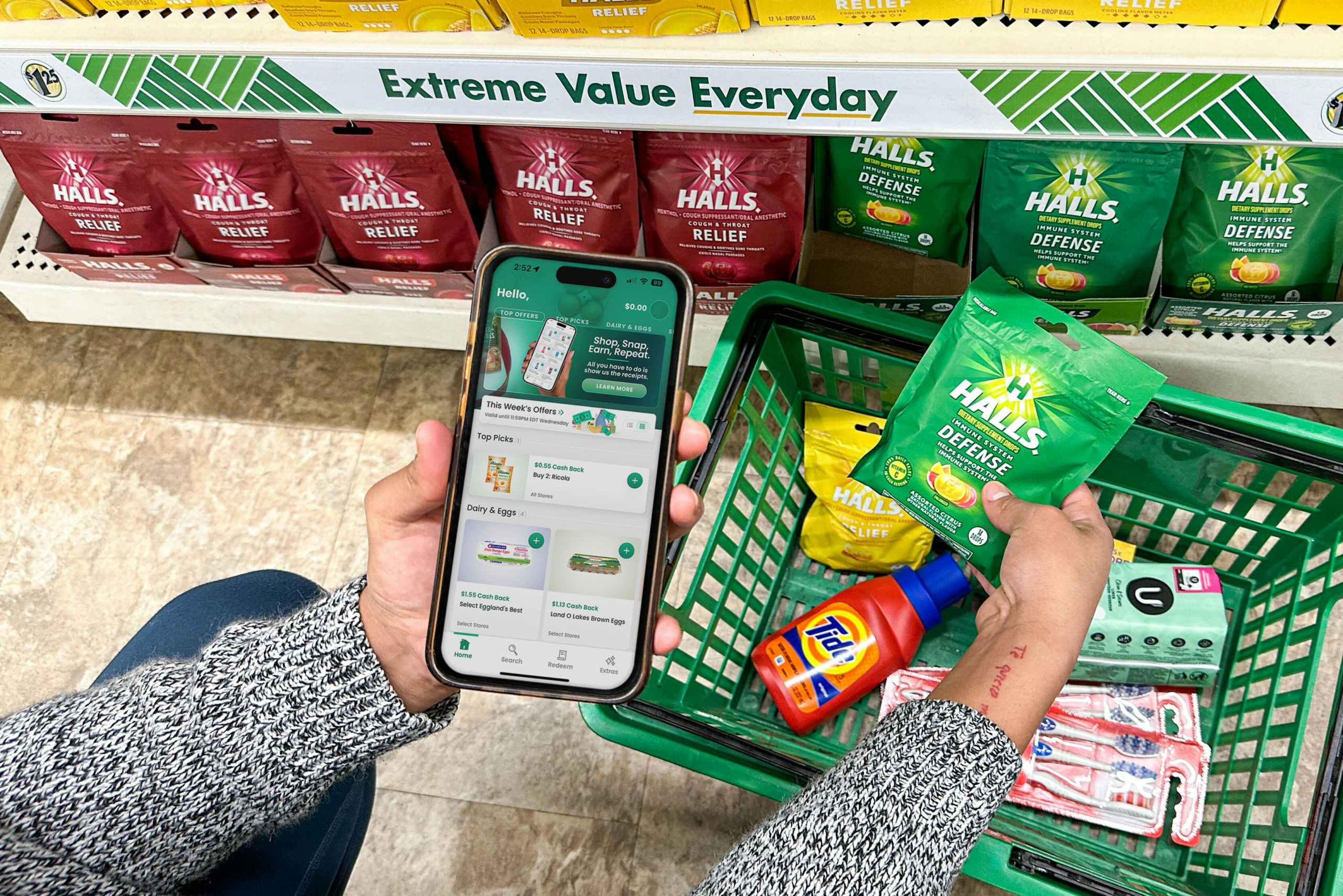 a person holding an iphone with a coupon app in the dollar tree store 