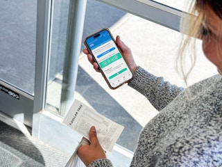 a person holding an iphone with a coupon app in the dollar tree store