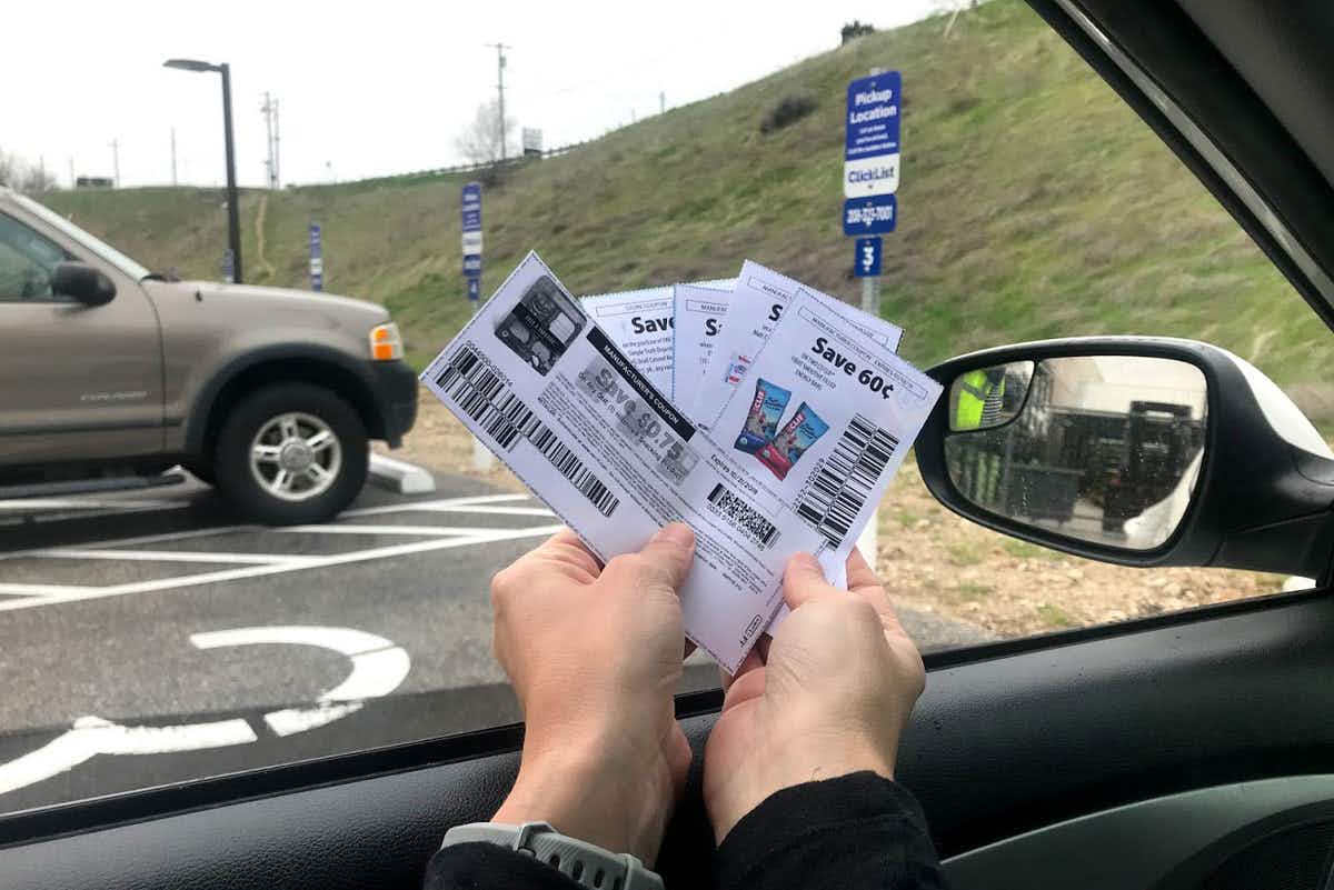 Person holding coupon while inside a car