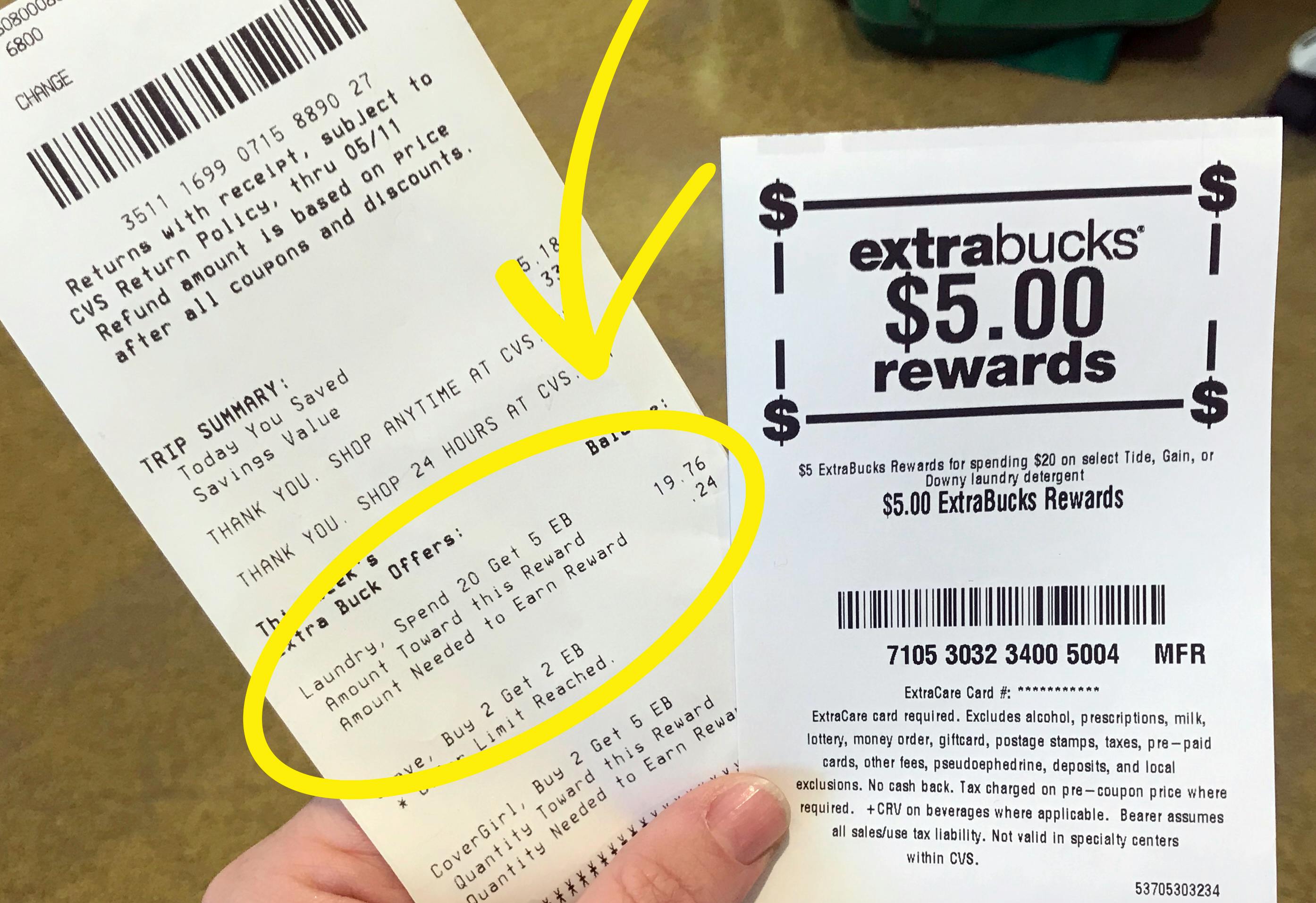 Someone holding a CVS receipt with a $5 ExtraBucks rewards receipt