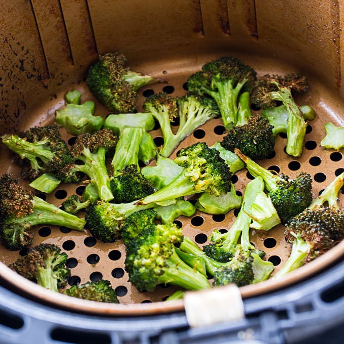Broccoli being cooked in an air fryer