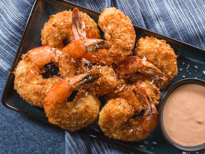 Coconut covered shrimp with dipping sauce nearby