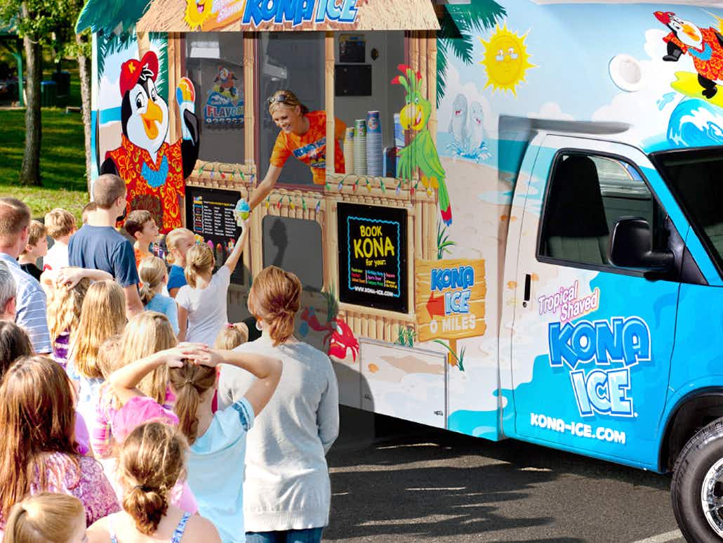 person serving kona ice to customers from truck