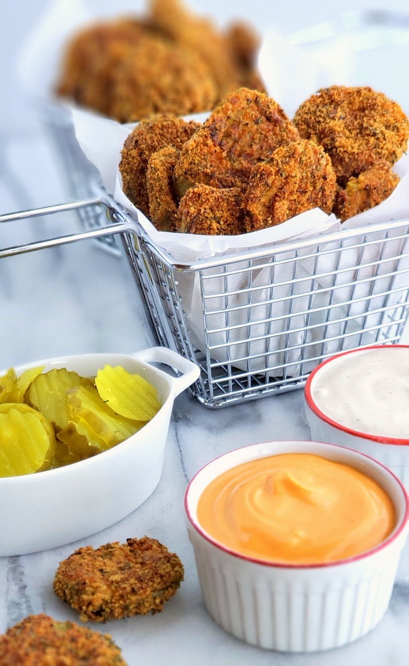 fried pickles in basket with dipping sauces nearby