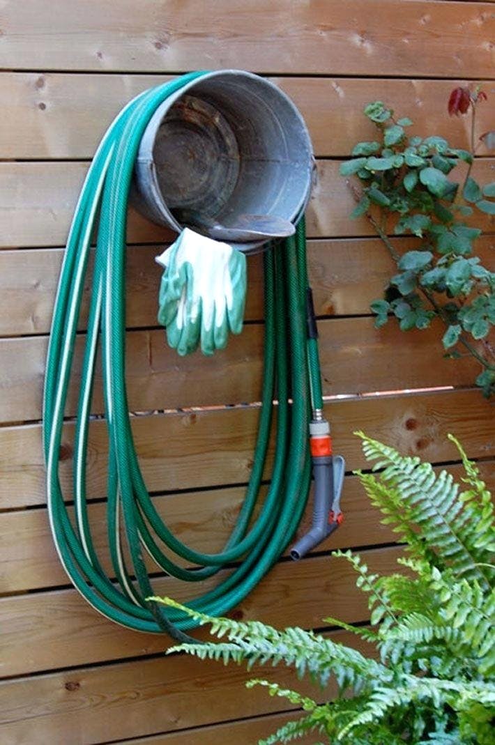 hose hanging from bucket on fence