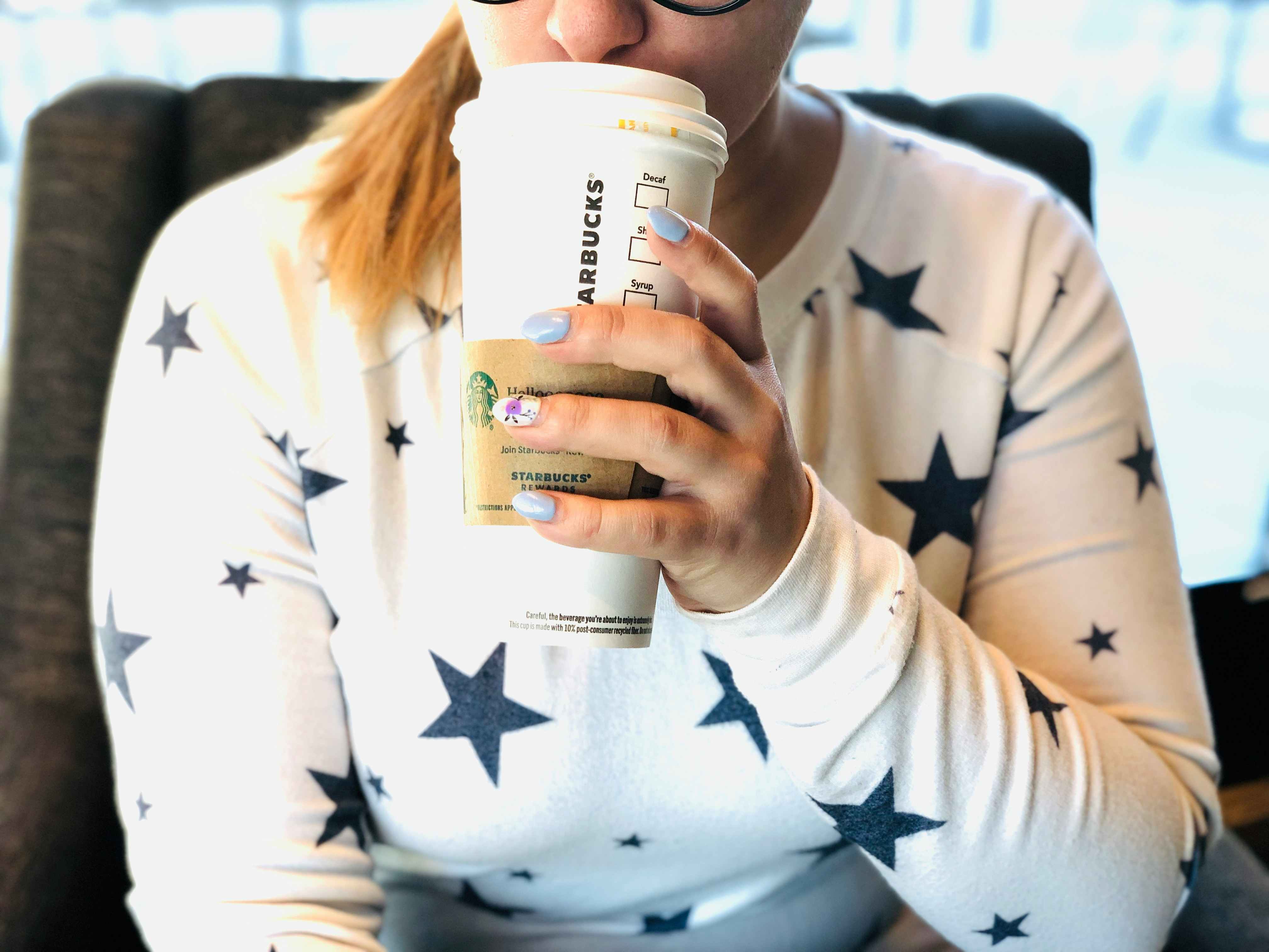 Woman sipping from a venti Starbucks cup