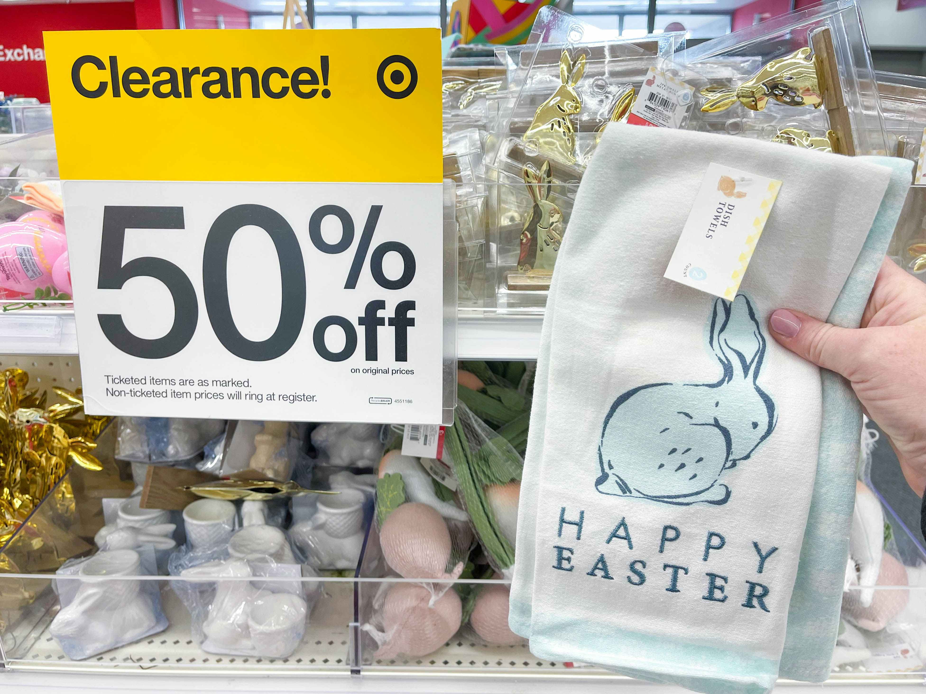 a happy easter hand towel being held in front of clearance 50% off sale sign in target