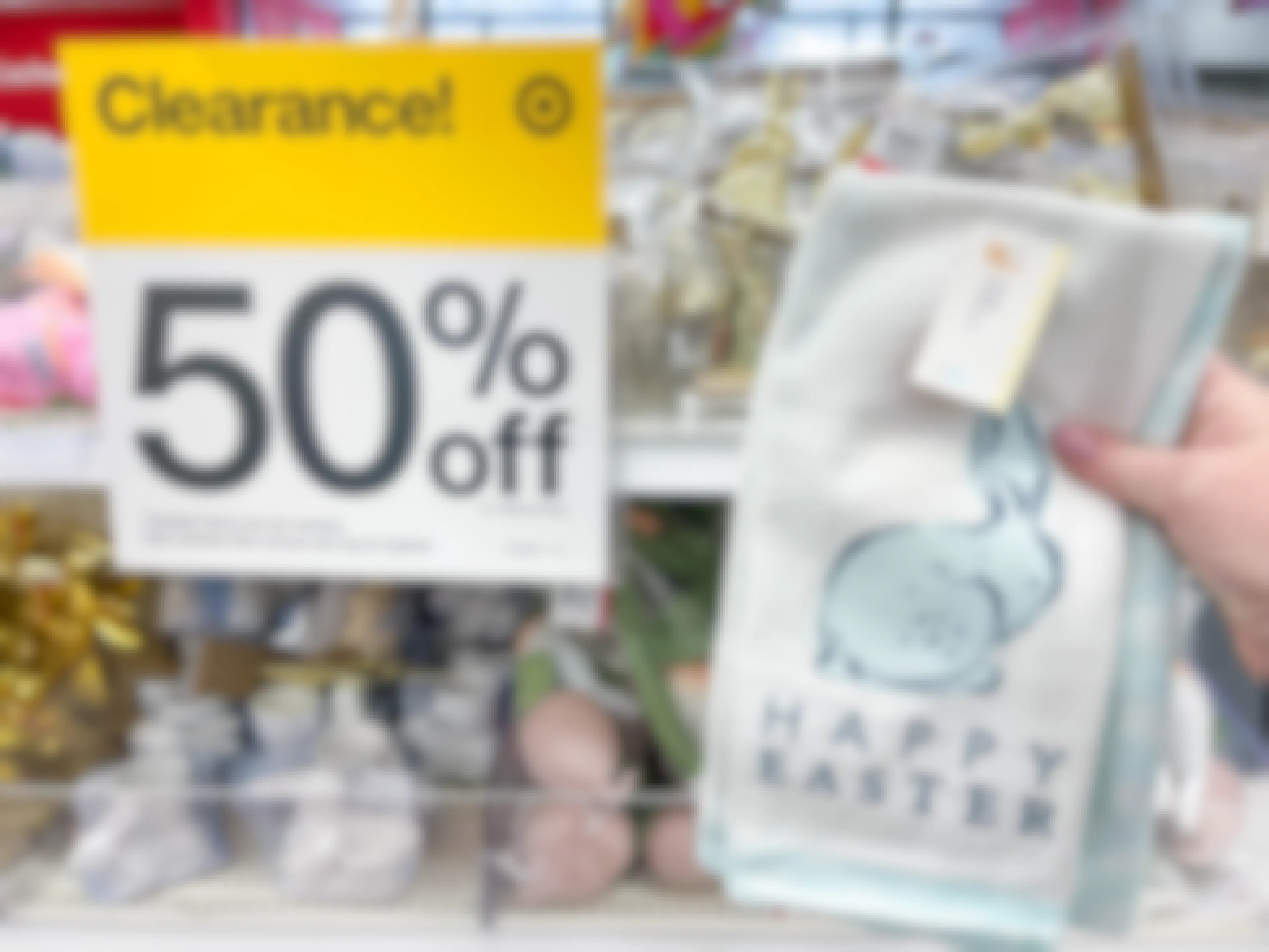 a happy easter hand towel being held in front of clearance 50% off sale sign in target