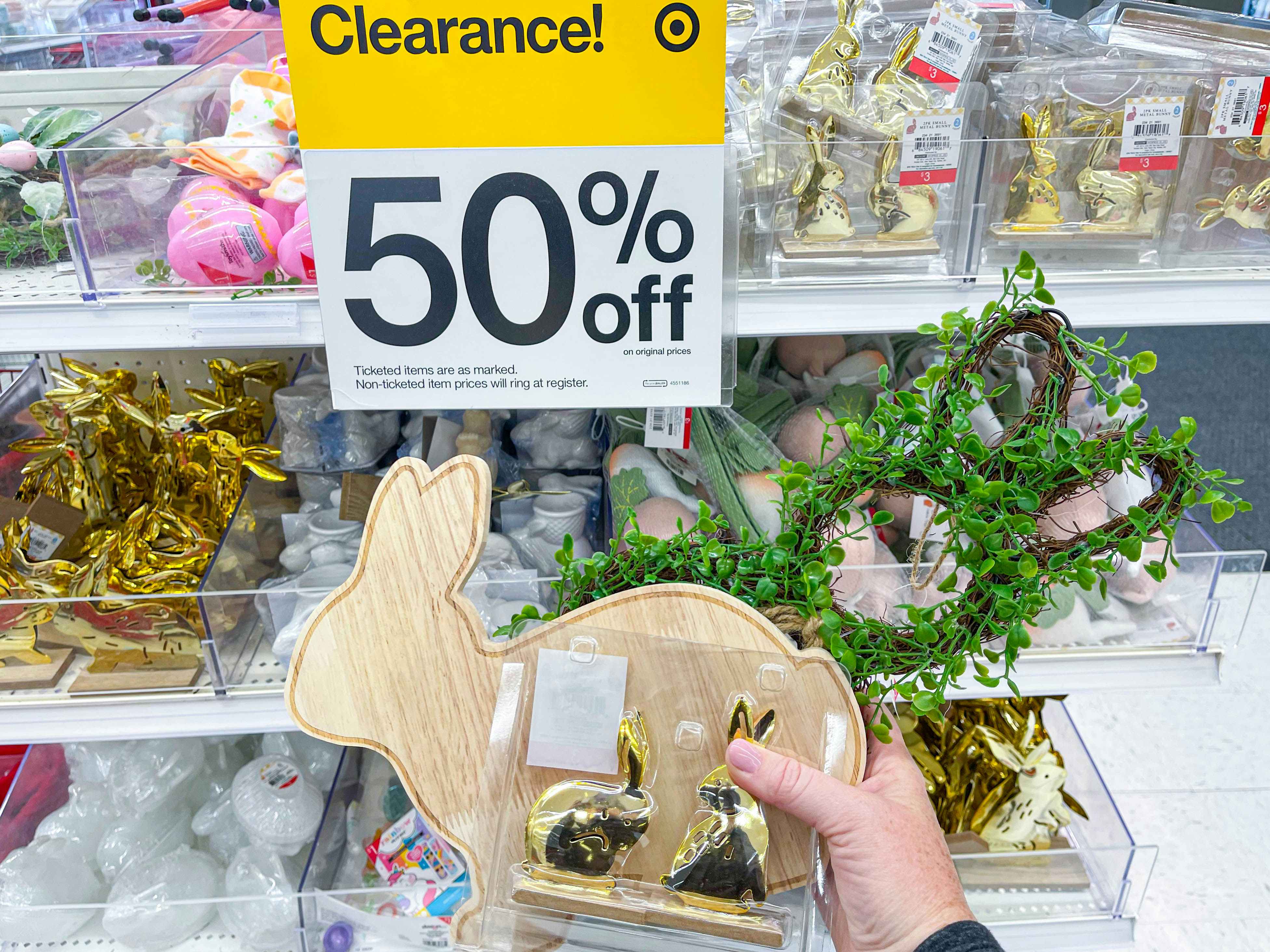 easter bunny decor being held in front of clearance sale sign in target
