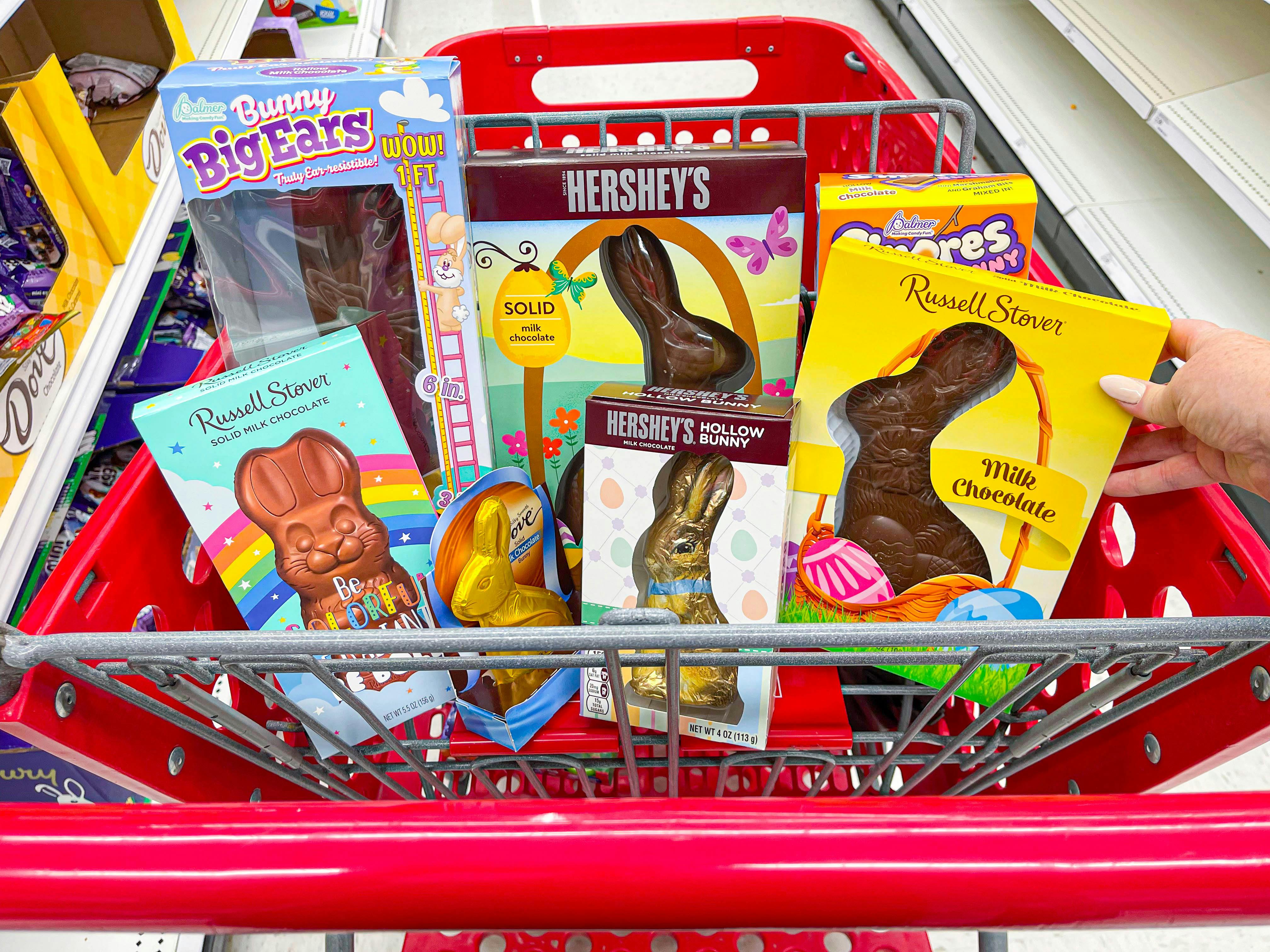 a target cart with the top basket filled with different types of chocolate easter bunnies