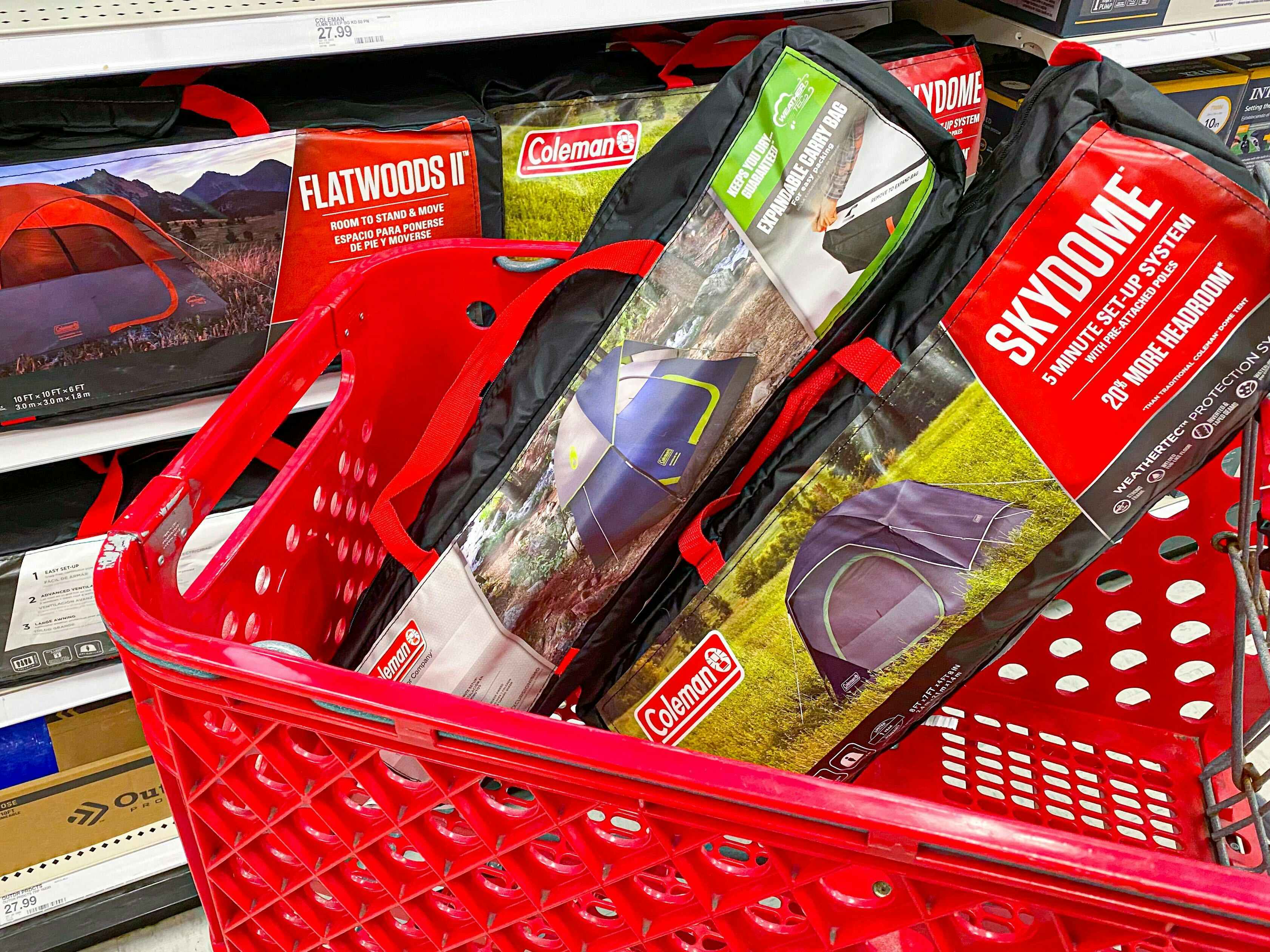 Two Coleman camping tents sitting in a Target shopping cart in the camping gear aisle at Target.