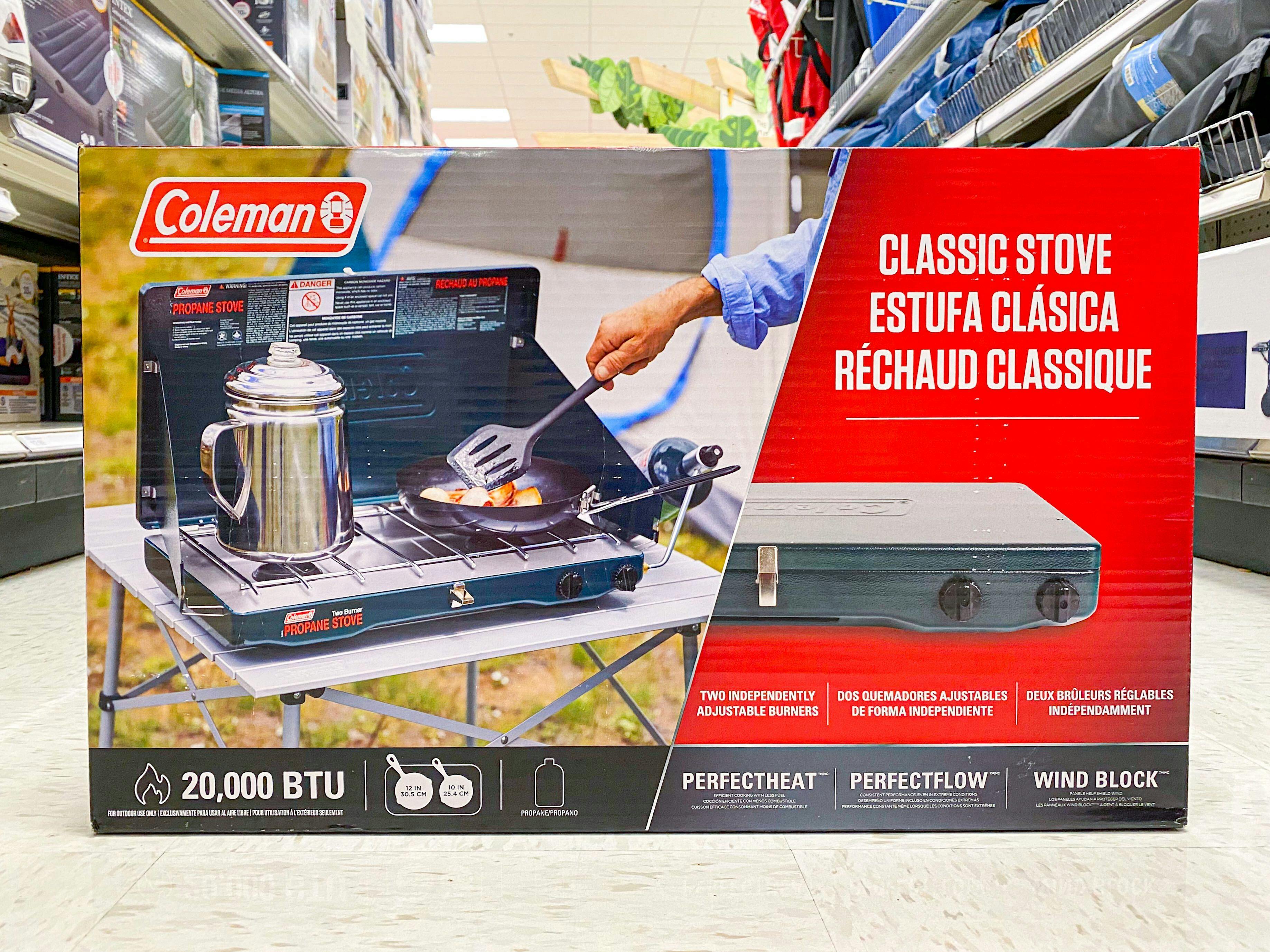 A Coleman camping stove sitting in the middle of the camping gear aisle at Target.