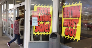 Store closing signs in a window of a store