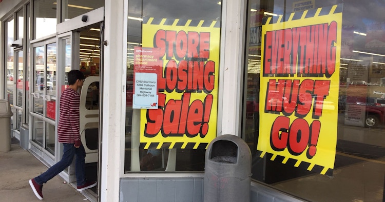 Store closing signs in a window of a store