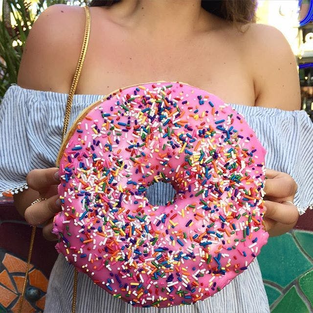 Woman holding a Lard Lad's donut from Universal Studios