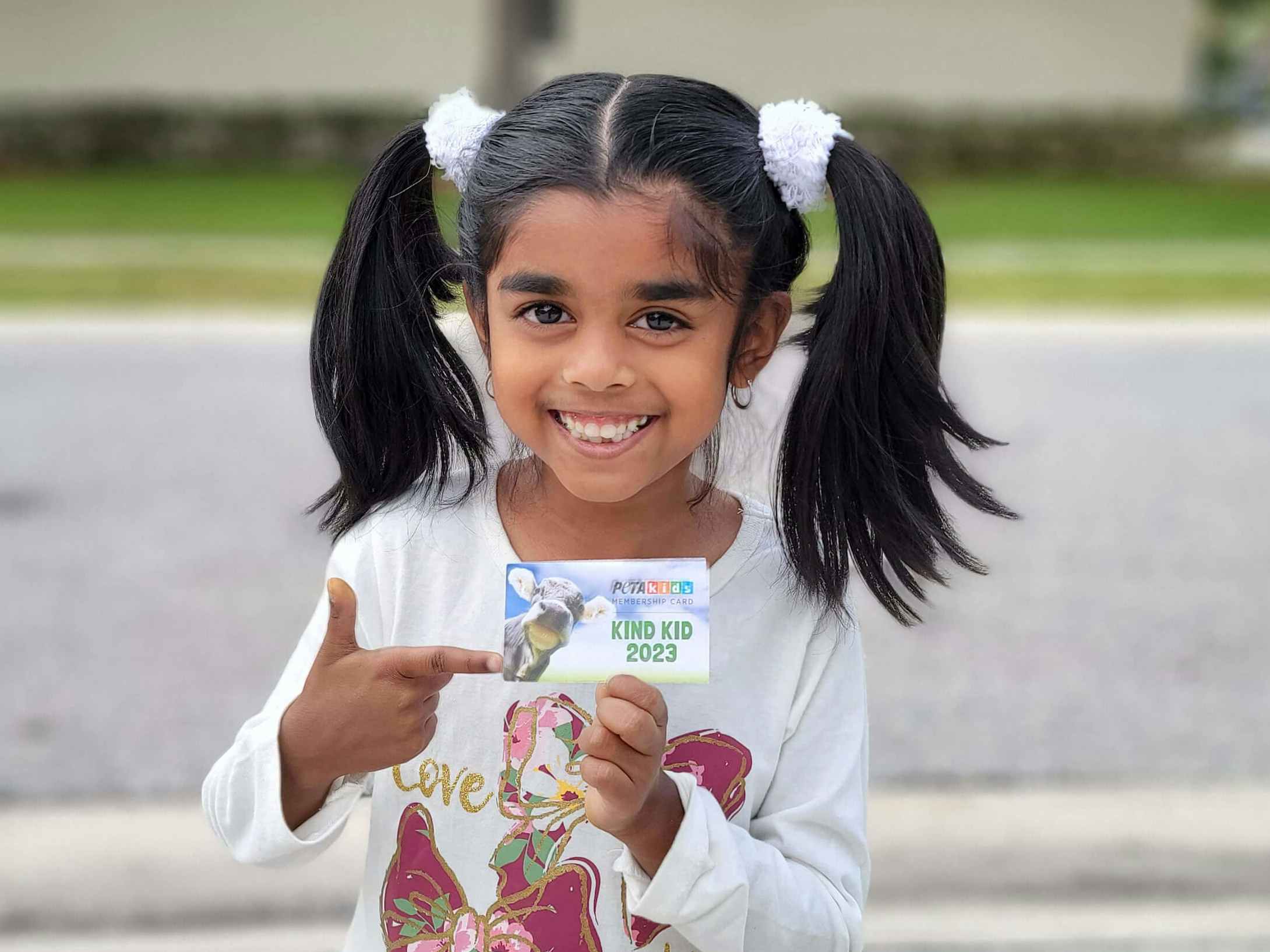 A child holding up a Peta kids membership card