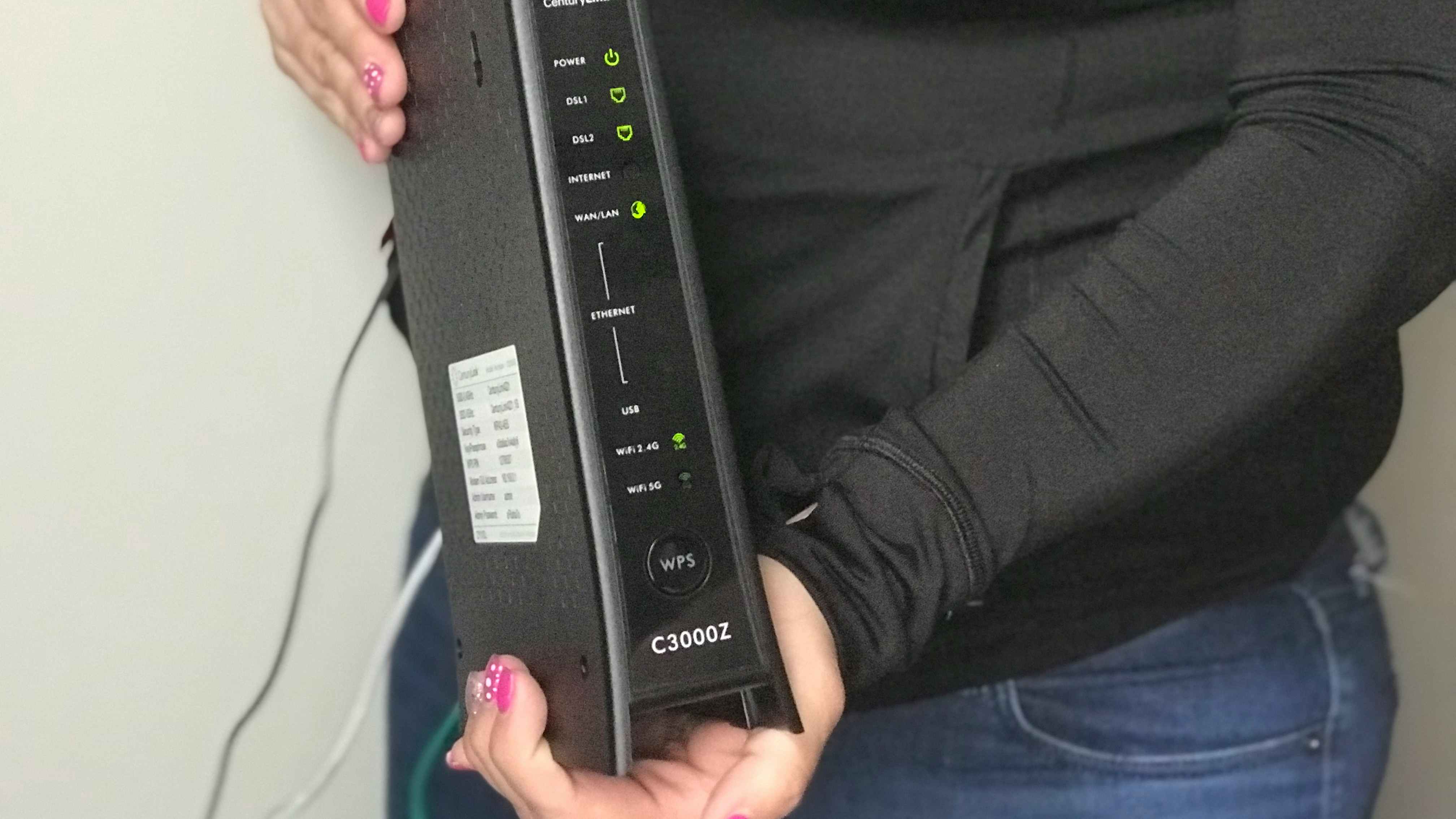 A woman holding an internet modem.