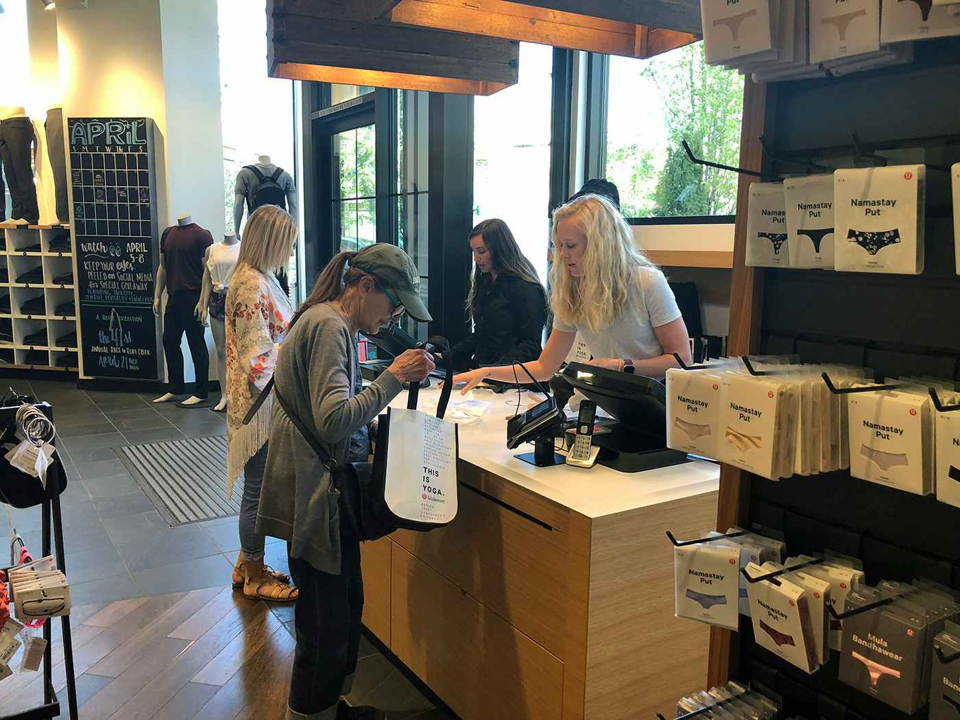 Woman reaching into her purse for a Military ID inside Lululemon