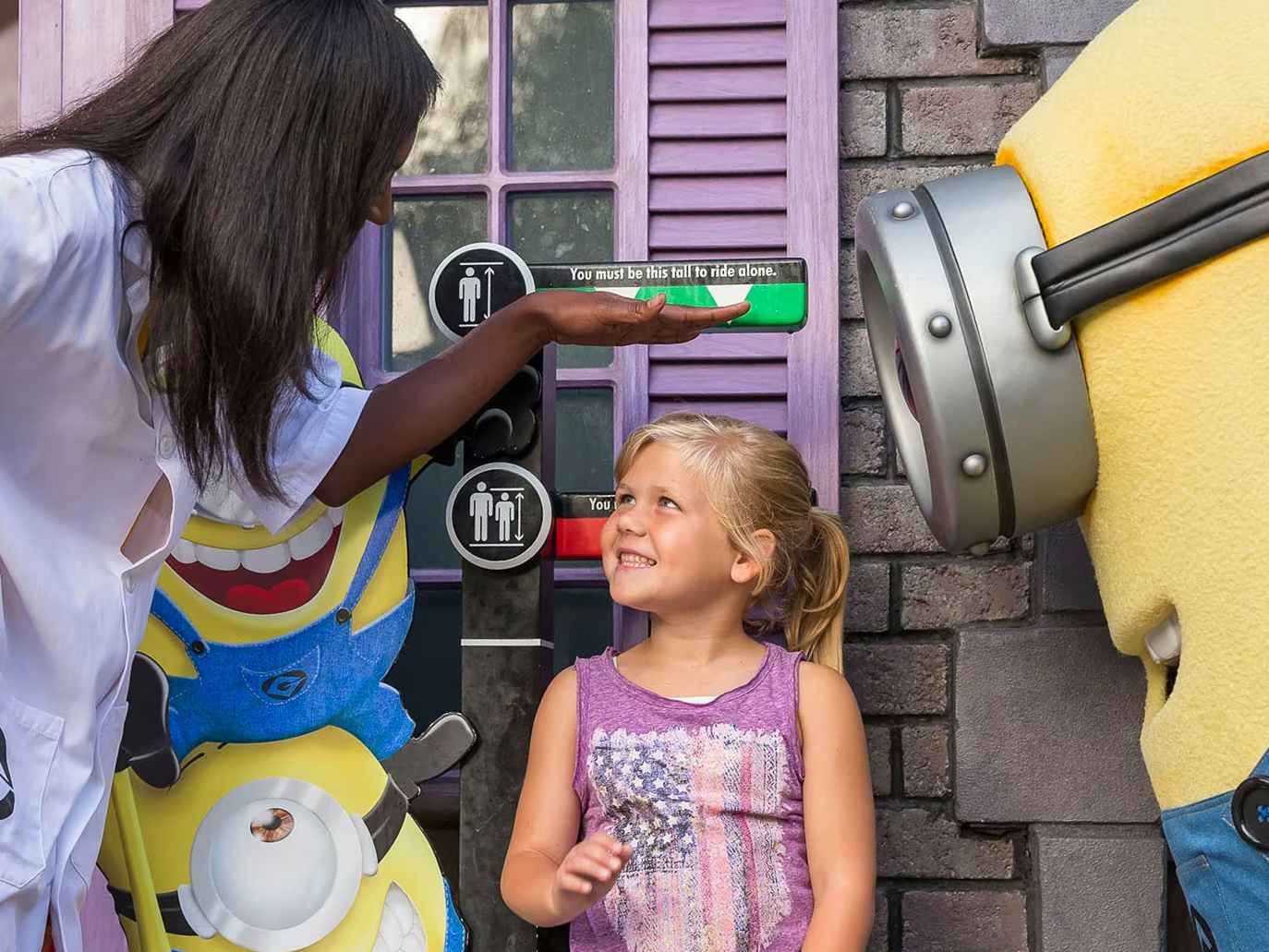 A little girl having her height measured before going on a ride