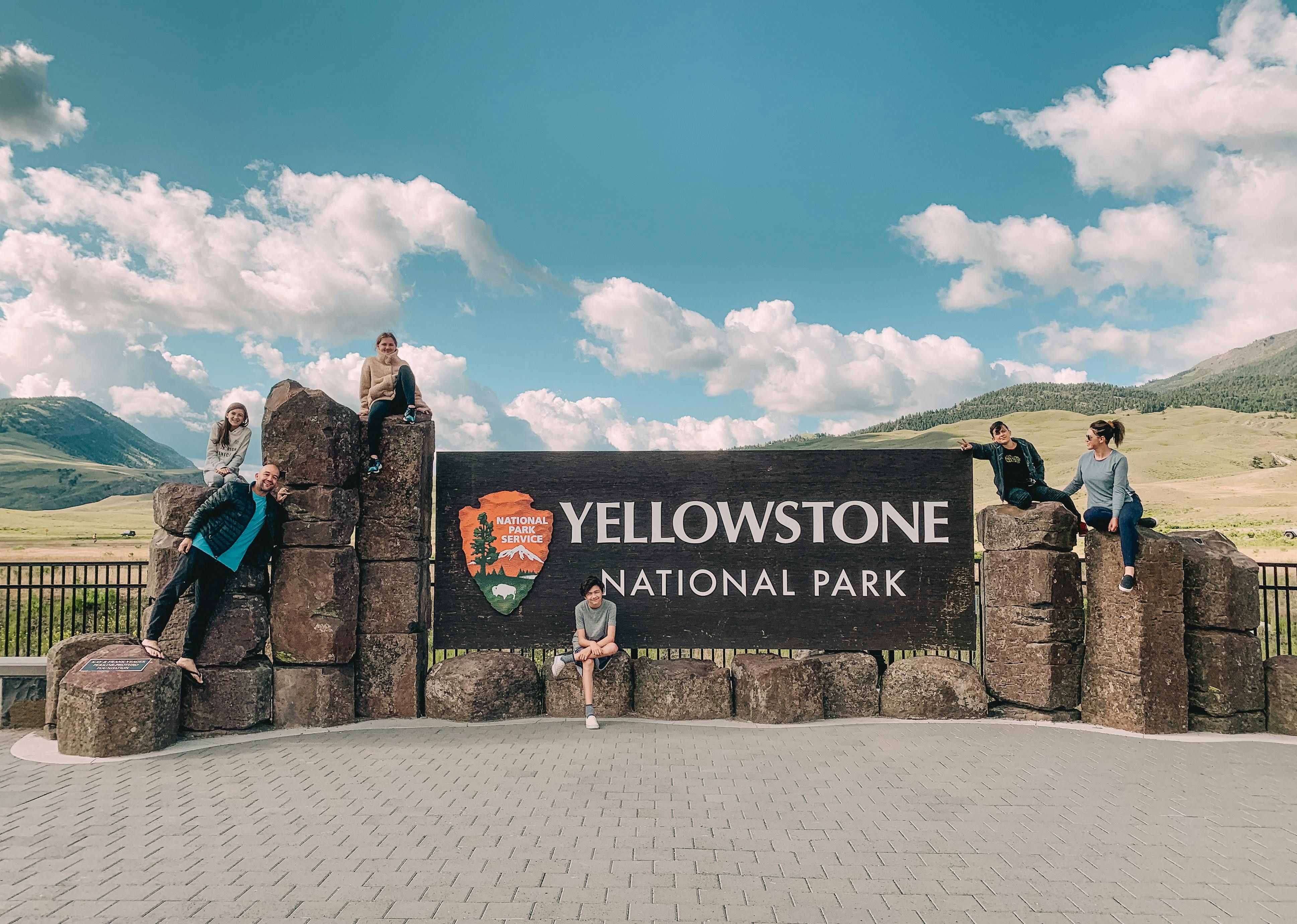 Family posing on the Yellowstone national park sign
