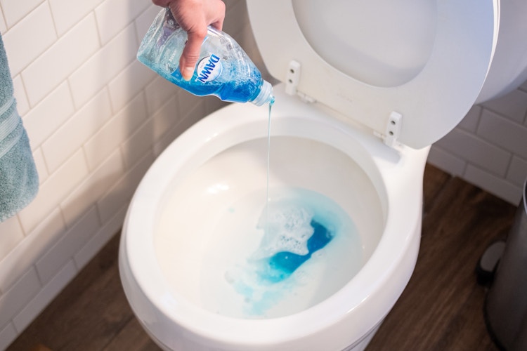 Dawn soap being poured into a toilet.