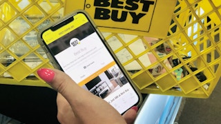 hand holds an iphone open to the KCL app with Best Buy selected