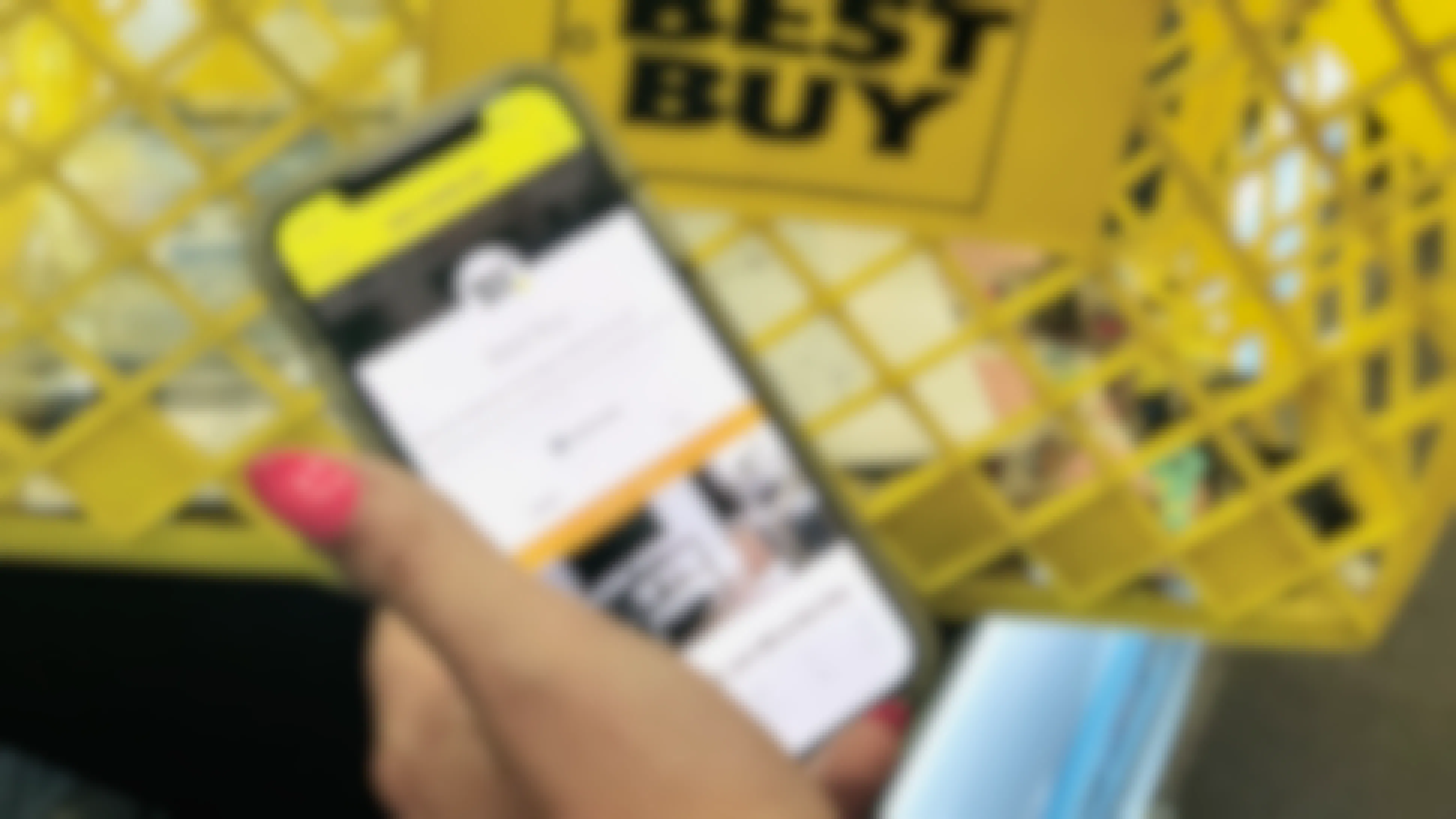 hand holds an iphone open to the KCL app with Best Buy selected