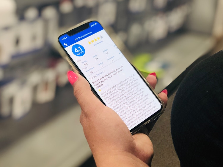 hand holds phone open to best buy app and reviews in the app