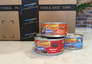friskies shreds wet canned cat food next to amazon boxes